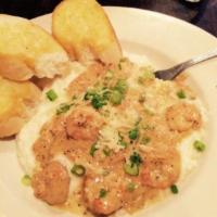 Shrimp and Grits Plate · Gulf shrimp sauteed in a cream of garlic sauce over grits and served with grilled French bre...