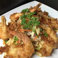 104. Coconut Shrimp · Golden-fried coconut shrimp on a bed of fruit salad tossed with lime sauce.