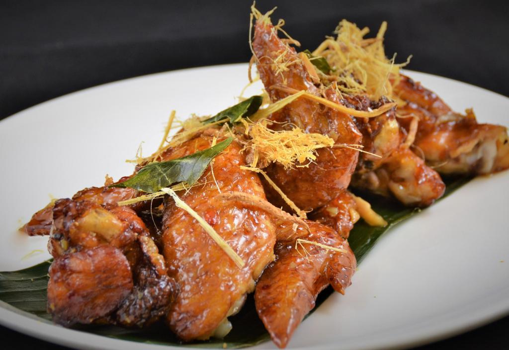 Peek Kai · Signature wing chicken wings marinated in fish sauce, deep fried, tossed in caramelized garlic sauce.