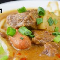 34. Beef Massaman Curry · Slow cooked beef, carrots, potatoes, onions and peanuts in a rich Thai mussamun curry with b...
