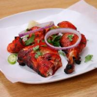 2 Pieces Tandoori Chicken Leg · Whole chicken leg and thigh, spicy marinated and broiled in tandoor.