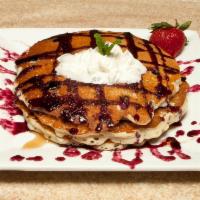 Blueberry Bliss Pancakes Breakfast · Full stack fresh blueberry pancakes served with maple syrup and butter.