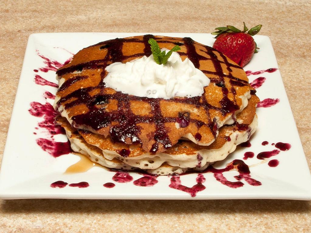 Blueberry Bliss Pancakes Breakfast · Full stack fresh blueberry pancakes served with maple syrup and butter.