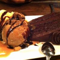 Chocolate Mud Cake with Vanilla Ice Cream · Served with whipped cream and chocolate sauce.