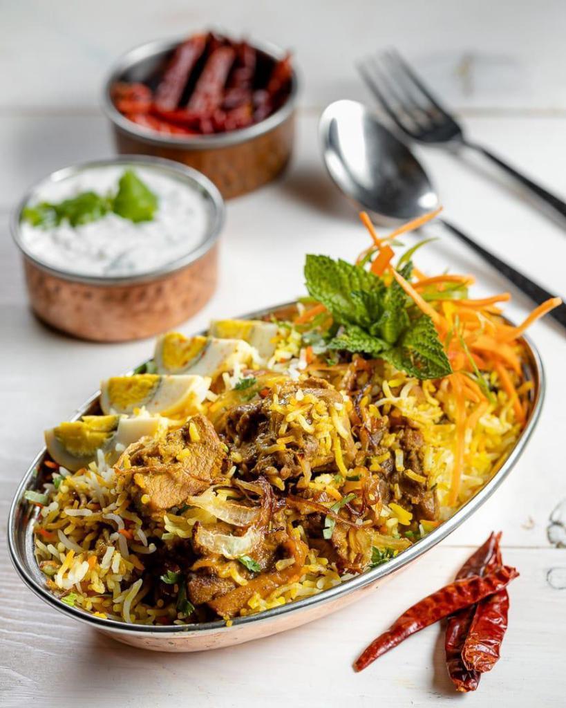 Chicken Biryani · (GF) Hearty vegetables/meat and rice casseroles cooked with flavorful herbs & spices. Served with yogurt cucumber raita
