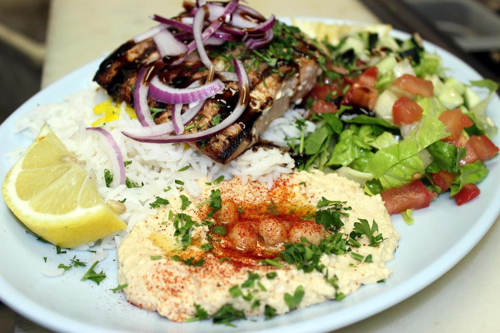 Grilled Salmon Plate · Flame grilled 8oz Wild Atlantic Salmon fillet marinated with Mediterranean herbs, garlic and house dressing. Served with rice, salad, hummus & pita bread. Substitutions of sides available.