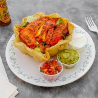 Tostada Salad · A crisp tortilla bowl (it's edible) filled with black or pinto beans, mixed greens, topped w...