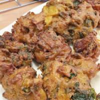 Vegetable Pakora · Potatoes, spinach, onion and cauliflower dipped in spicy chickpeas and fried. Vegetarian.
