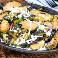 Charred Brussels Sprouts · Fire-roasted with bacon,  hot honey, and ricotta salata.