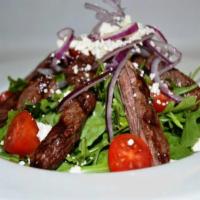 Skirt Steak Salad · Fresh arugula, tomatoes, red onions, Feta cheese and grilled skirt steak.