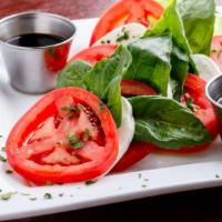 Caprese Salad · Fresh mozzarella, tomatoes and basil leaves layered and drizzled with balsamic and extra vir...