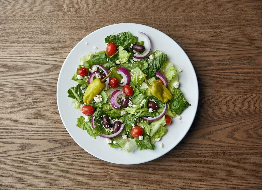 Greek Salad · Iceberg and romaine mix with tomatoes, onions, feta cheese, pepperoncini peppers and Greek olives.