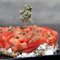 Dakos Salad · Traditional cretan dry bread topped with chopped plum tomatoes, Arahova feta, and capers fla...