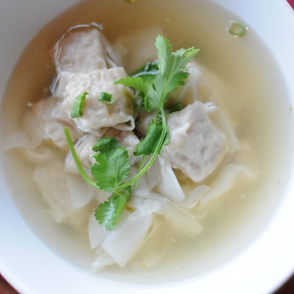 Wonton Soup · Homemade wontons stuffed with ground pork and prawns served with bok choy in a clear broth soup topped with green onions and cilantro.