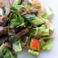 28. Crying Tiger Salad · Grilled New York steak tossed with lime-sauce, cucumber, red and green onions and toasted ri...