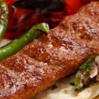Lamb Adana Kebab · Skewered chopped meat. Served with rice and mixed greens.