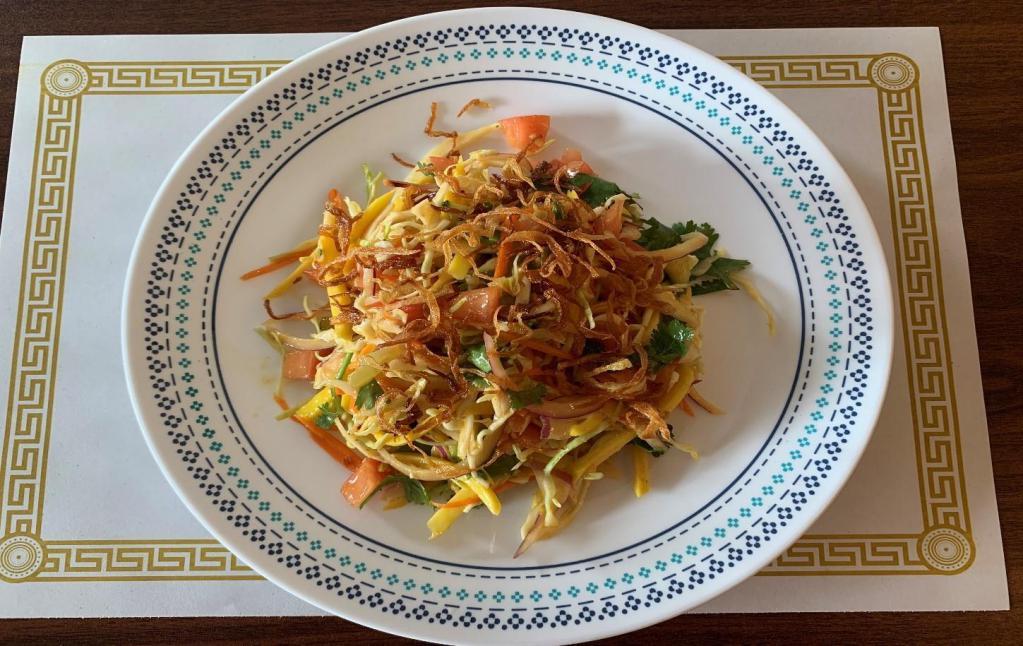 13. Mango Salad · Shredded pickled mangos mixed with cabbage, tomato, red onion, cucumber, carrot and fried onion on top.