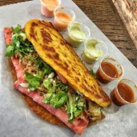 Cuban Style Cachapa · Sweet corn pancake with ham, slow cooked roast pork and cheese topped with lettuce, tomato, ...