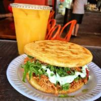 Shredded Chicken Fried Arepa · Traditional Cornmeal Cake with shredded chicken topped with lettuce, tomato, fried cheese, o...