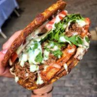 Shredded Beef Patacon · Twice Fried Green Plantain sandwich with Shredded Beef topped with lettuce, tomato, fried ch...