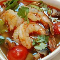 S2. Tom Yum · Tangy lemongrass soup with mushrooms, tomatoes, scallions and cilantro infused with chili pa...