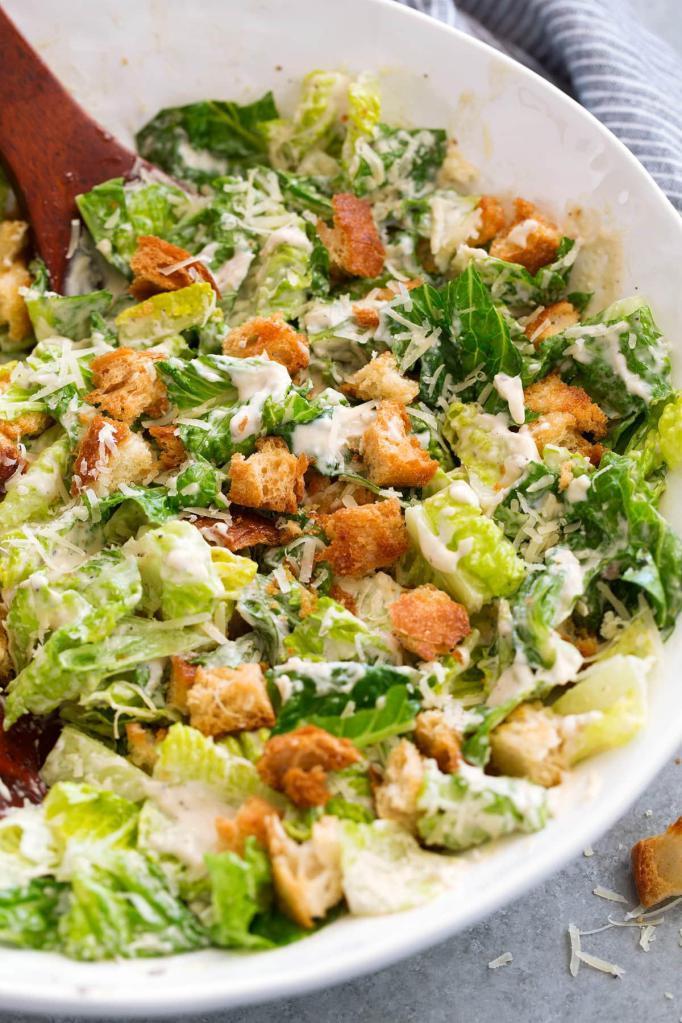 Caesar Salad · is loaded with fresh romaine, croutons, Parmesan, and chicken or without all tossed in a homemade Caesar dressing!