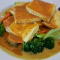SP20. Tofu Paradise · Steamed tofu over a bed of mix vegetable in yellow curry sauce with peanut sauce on top. Spi...