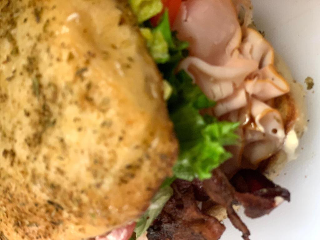 Turkey Bacon Avocado Sandwich · Natural turkey breast, thinly sliced with fresh avocado spread, crispy bacon, lettuce, tomato, and mayonnaise on a herb Ciabatta bun. 