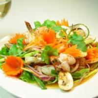 Seafood Salad · Steamed shrimp, mussels and crab marinated with a spicy sauce and shredded carrots on a bed ...