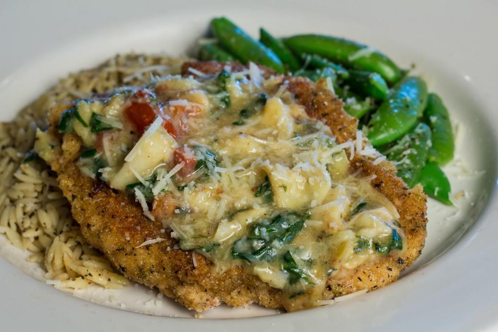 Herb Crusted Chicken · Herb parmesan crusted chicken, topped with lemon butter sauce, tomatoes, fresh spinach, and artichoke hearts. Served over orzo pasta with a side of sautéed broccoli.