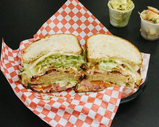 Triple Decker Club for Two · House smoked real turkey and hickorywood slow smoked ham, thick cut applewood bacon, smoked muenster cheese, house mayo, French Dijon, tomato, and iceberg lettuce on a Pearl Bakery Levain sourdough.