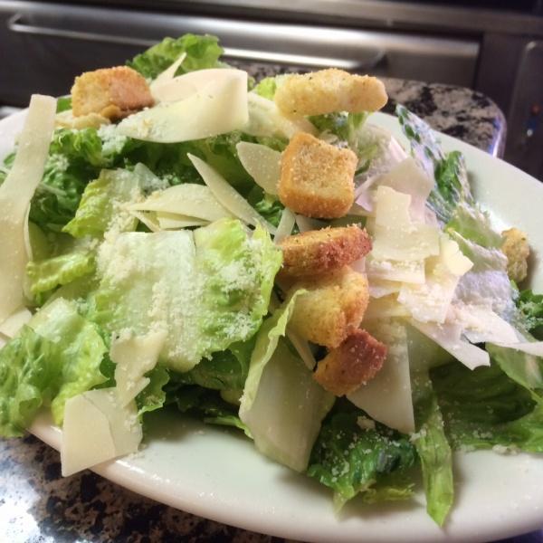 Caesar Salad · Crisp, fresh romaine lettuce mixed with creamy Caesar dressing and topped with croutons and shaved Parmesan cheese.