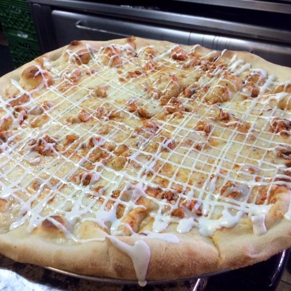 Buffalo Chicken Pizza · Freshly made pizza dough with grilled chicken tossed in a spicy wing sauce and drizzled with ranch dressing.
