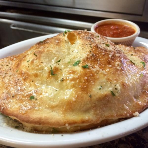 Cheese Calzone · Our freshly made dough filled with seasoned ricotta cheese and mozzarella. Served with fresh marinara sauce.