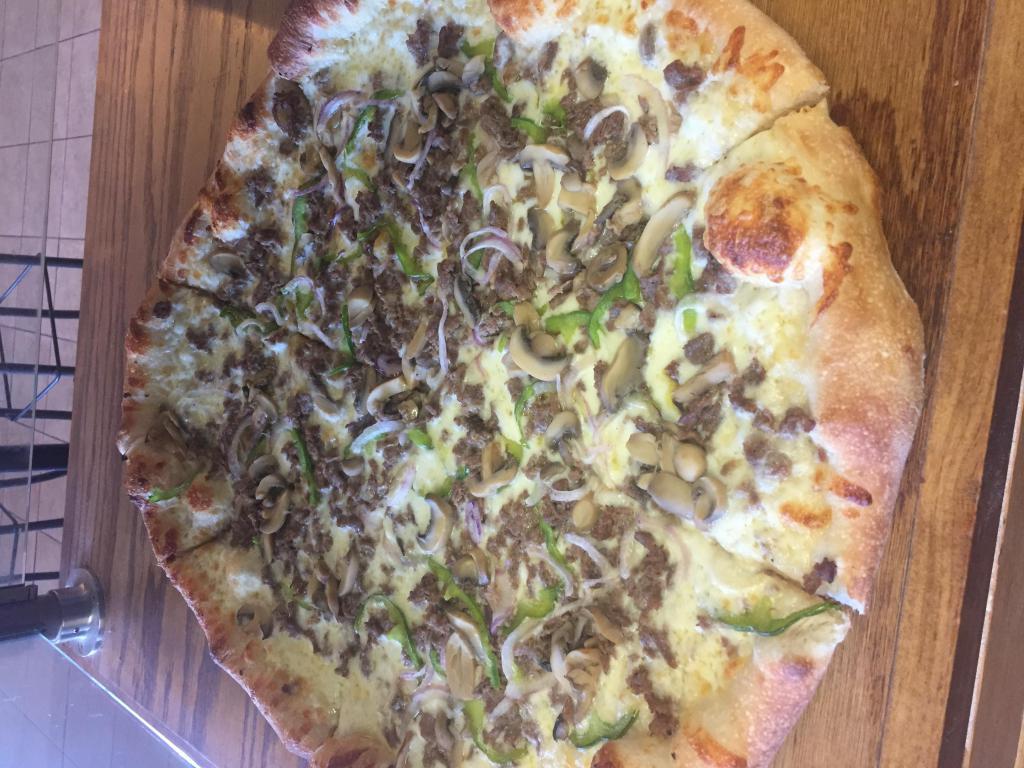 Philly Cheese Steak Pizza · Shaved steak, red onions, green peppers, mushrooms, provolone, and mozzarella cheese.