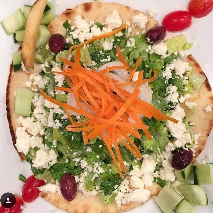 Chopped Greek Salad · Romaine hearts, tomatoes, cucumbers, onions, olives, feta, grilled pita and Lemon infused olive oil dressing 