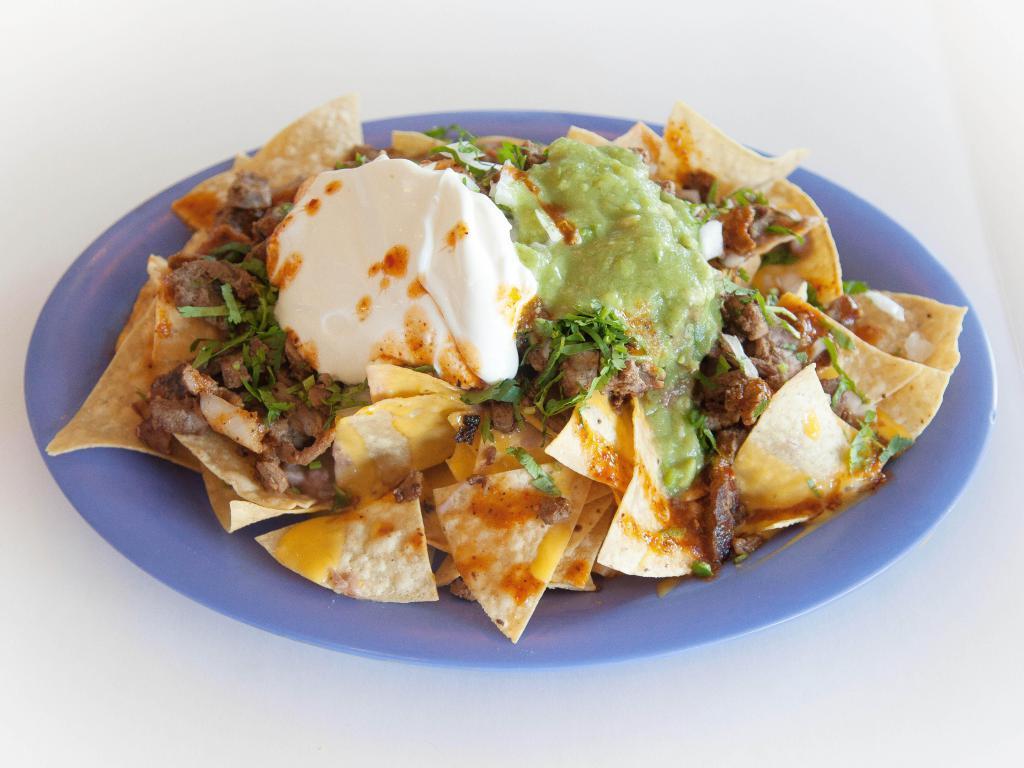 Nachos Way · Tortilla chips, beans, yellow cheese, meat, cilantro, onion, sour cream, red sauce, guacamole.