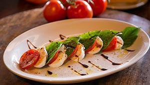 Insalata Caprese · Perfectly ripened Roma tomatoes, fresh mozzarella and garden-fresh basil, drizzled with bals...