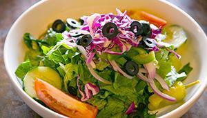 House Salad · Romaine lettuce, red onions, bell peppers, cucumbers, Roma tomatoes, red cabbage, black oliv...