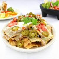 Fiesta Nachos · Our homemade corn tortilla chips topped with refried beans, melted cheese, jalapenos, guacam...