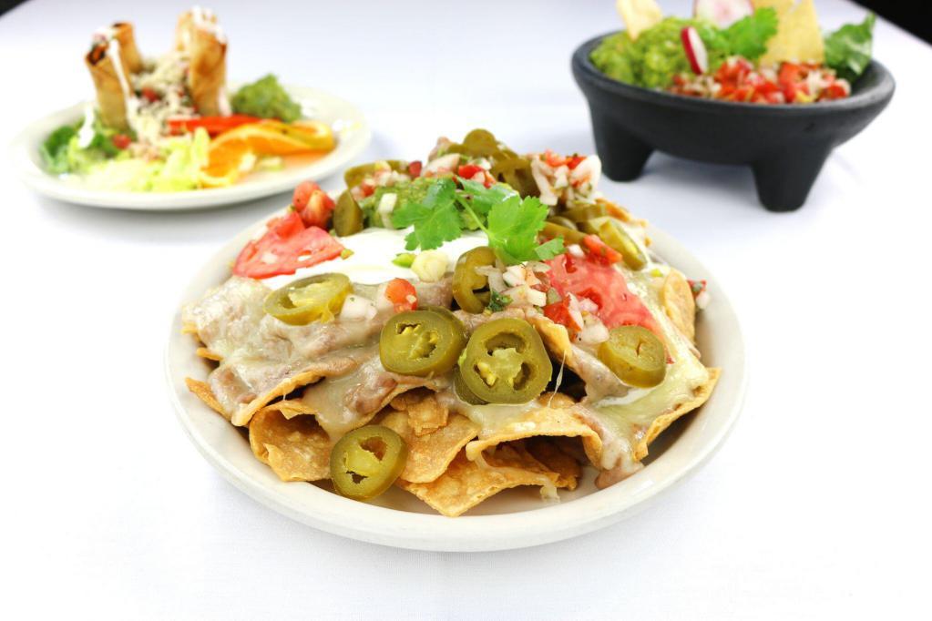 Fiesta Nachos · Our homemade corn tortilla chips topped with refried beans, melted cheese, jalapenos, guacamole and sour cream.