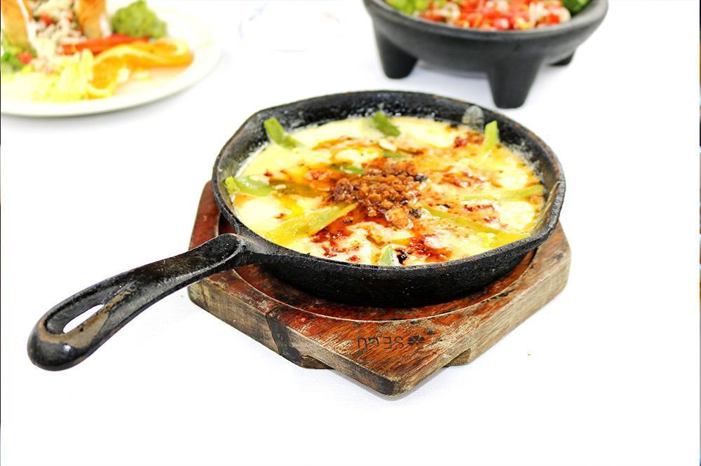 Queso Fundido · Hot melted cheese topped with chorizo served with corn or flour tortillas.