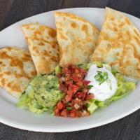 Quesadilla · King size flour tortilla, melted cheese garnished with guacamole and sour cream.