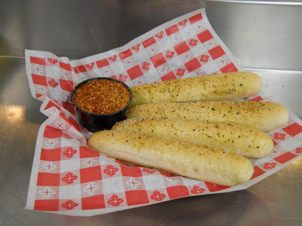 Soft Bread Sticks · Four soft bread sticks seasoned with our special garlic seasoning, topped with Romano cheese and served with a side of marinara sauce for dipping.