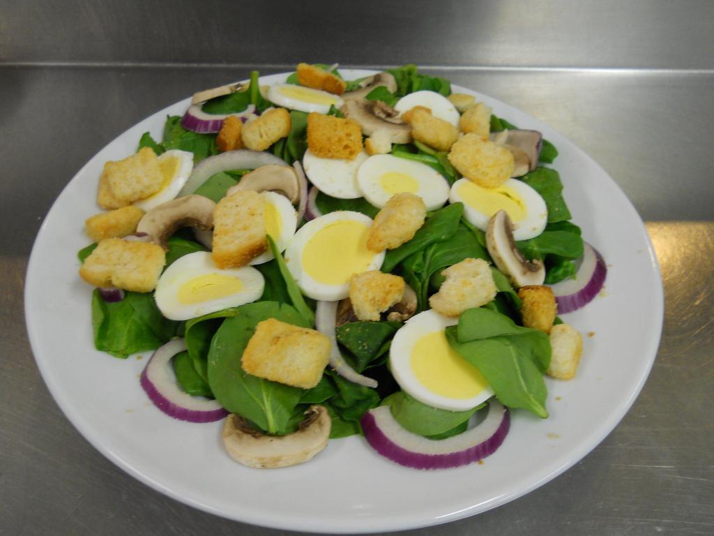 Fresh Spinach Salad · Fresh spinach leaves with slices of hard boiled egg, sliced red onion, fresh sliced mushrooms and croutons. 