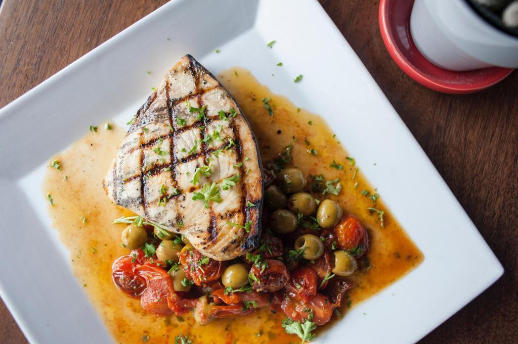 Grilled Sword Fish Steak · Served with green olives and cherry tomatoes sauté