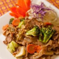 Pad See-Eiw · Pan-fried flat rice noodles with meat, broccoli, carrots, cabbage and egg in black sweet bea...