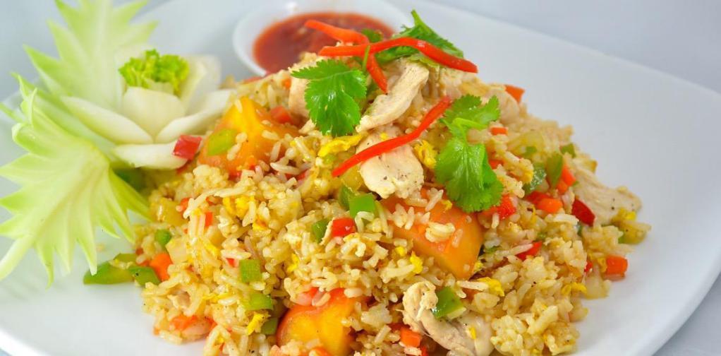 Thai Fried Rice · Fried rice with choice of protein, egg, onions, tomatoes, peas carrots topped with cilantro, cucumber and lime slices 