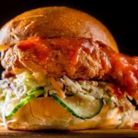 Spicy Crispy Chicken Sandwich · Crispy chicken sandwich topped with spicy wing sauce and garnished with pickled cucumbers an...