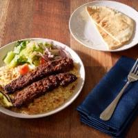 Adana Kabab · Ground beef, onion, parsley, spices, served with hummus, salad, rice, onion and pita bread.